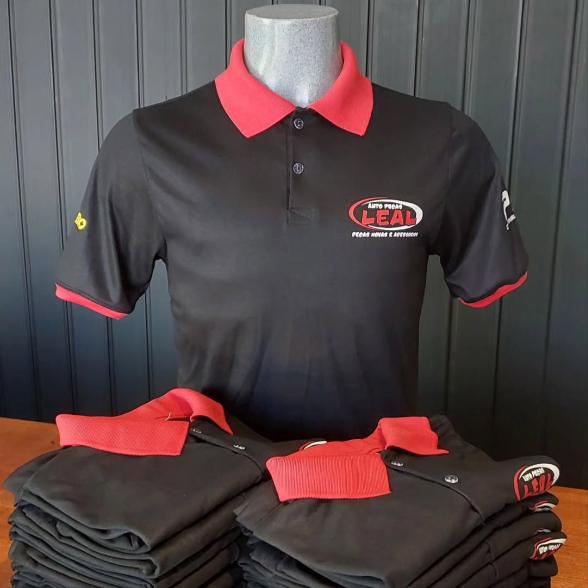 Camisas polo pretas com gola vermelha e logo bordado, produzidas pela LAESC